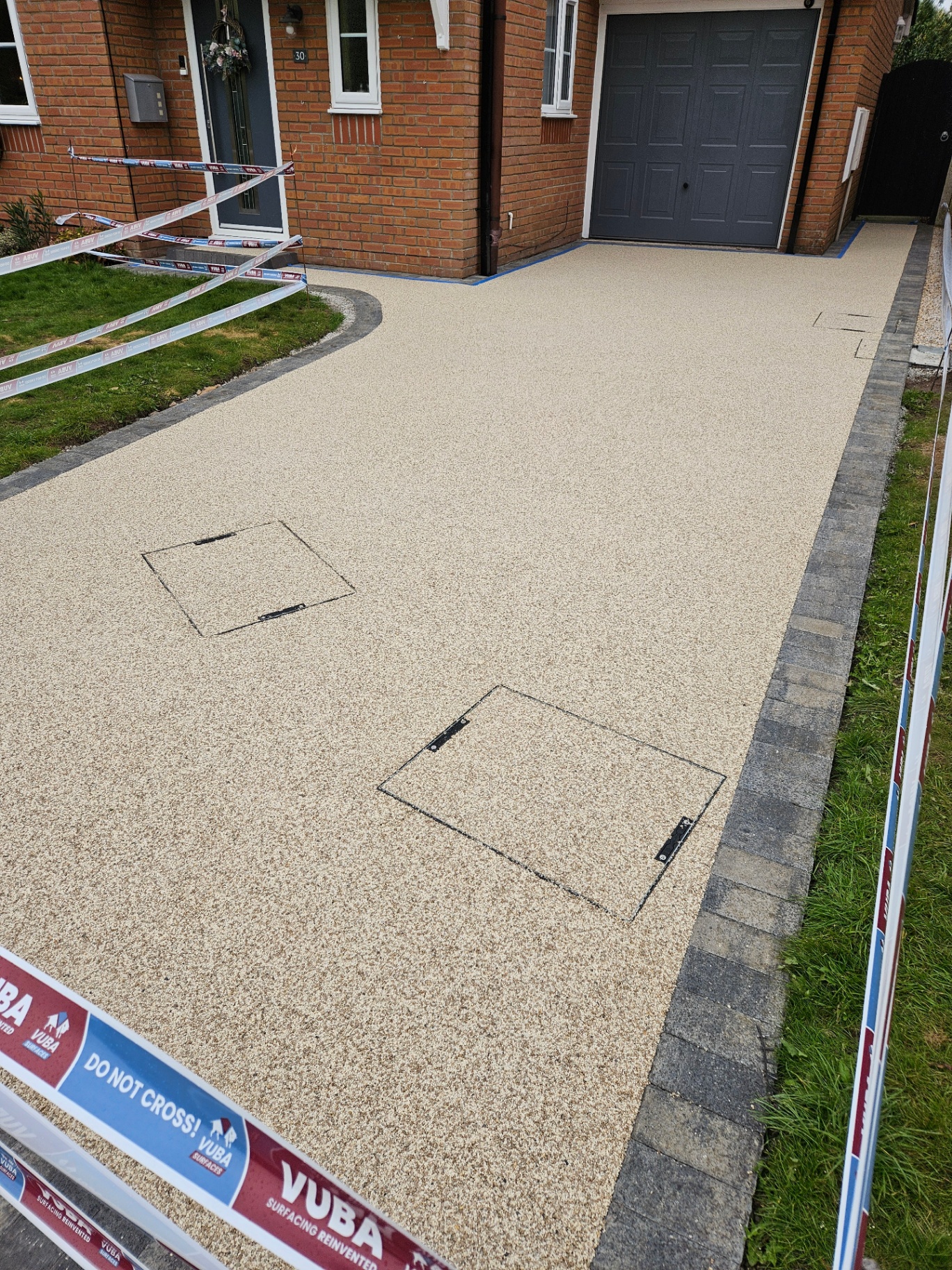 Amalfi resin bound driveway with a Tobermore Pedesta border in Slate and recessed inspection covers in Winterley